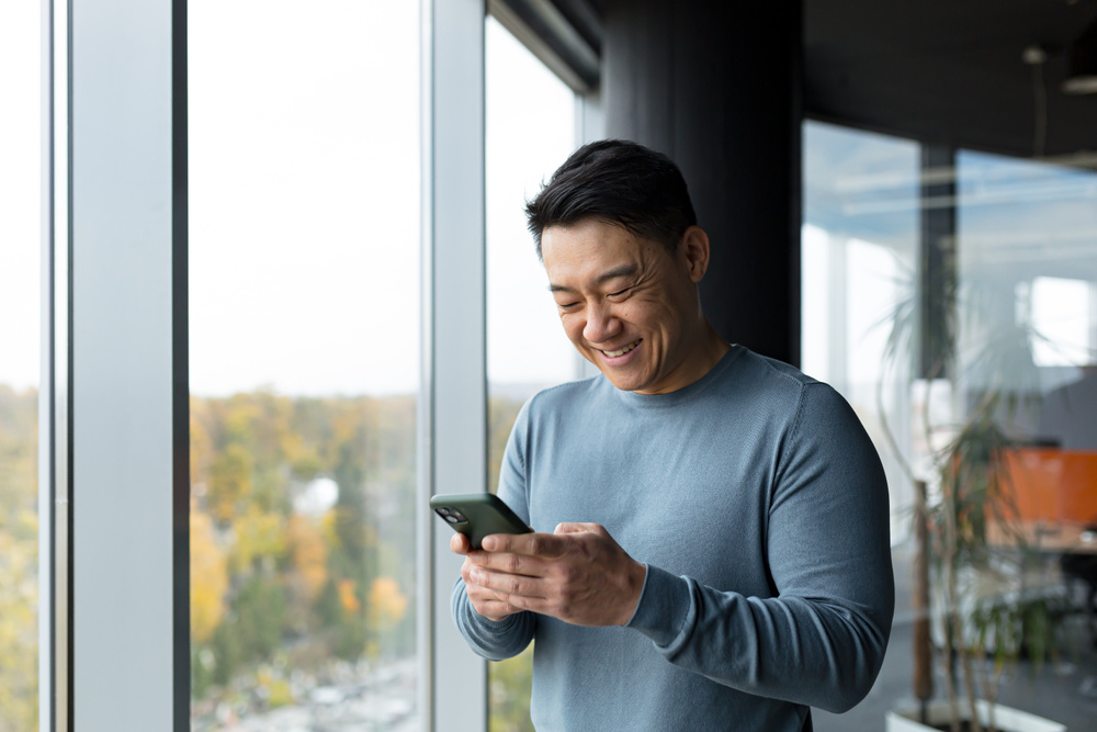 An middle-aged man using his phone to access the Pyx Health app.