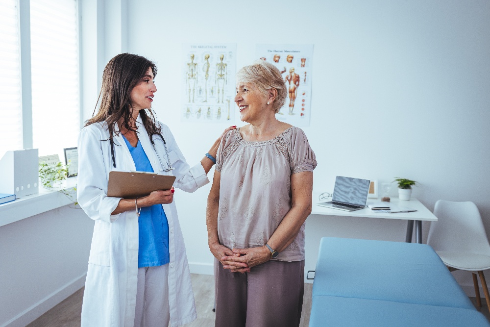 A doctor comforts an older patient during an appointment. 